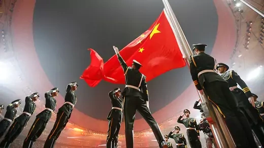 Soldiers raise China's national flag in the Olympic stadium. 