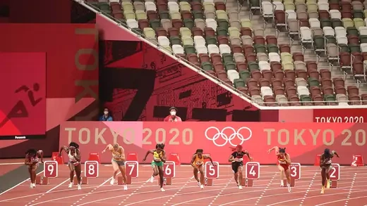 Sprinters race in an empty stadium.