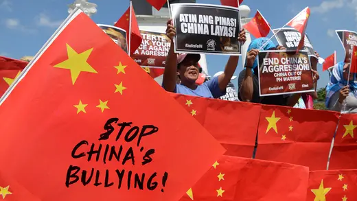 People hold signs during a protest saying Stop China's Bullying.