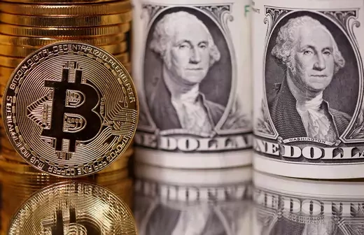 Bitcoin representations next to U.S. Dollars