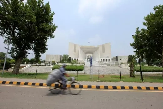 A man rides a bicycle past the Supreme Court building in Islamabad.