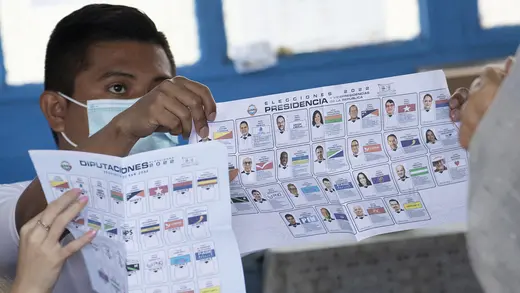 An election worker shows the presidential ballot to voters in San Jose, Costa Rica. 