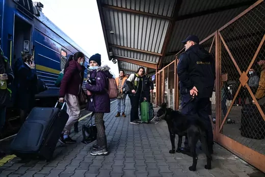 Ukrainian citizens carry suitcases as they exit a train arriving from Odessa via Lviv at Przemysl main train station on February 24, 2022 in Przemysl, Poland.