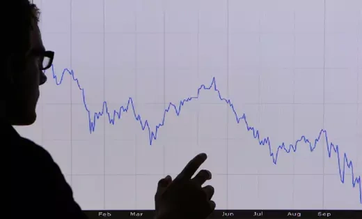 In this photo illustration, a man looks at a graph representing the 12 month decline of the FTSE 100 share index on October 7, 2008 in London. Financial markets are still suffering large losses as the global banking crisis continued.