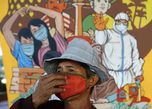 A man wearing a protective face mask walks near a mural promoting awareness of the coronavirus disease (COVID-19) outbreak in Jakarta, Indonesia, December 1, 2020.