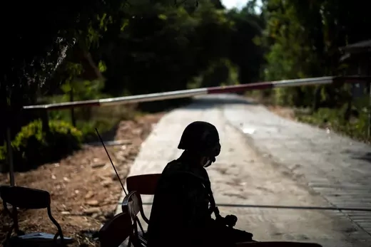 A Thai soldier sits in front of the blockage of a road leading to the Thailand-Myanmar border where the fighting between the Myanmar army and ethnic minority rebels still continues, in Mae Sot district, Tak province, Thailand, on December 19, 2021.