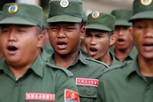 Soldiers, wearing green fatigues and United Wa State Army insignia, march in Myanmar.