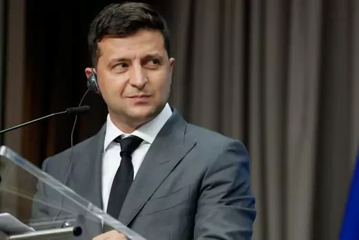 President Volodymyr Zelensky speaks at a podium after a meeting in Brussels.