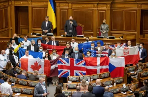 Ukrainian lawmakers hold state flags of Ukraine's partners to show their appreciation of political support and military aid during a session of parliament in Kyiv, Ukraine February 1, 2022.