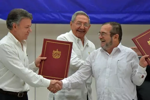 President Juan Manuel Santos shakes hands with FARC leader Timoleon Jimenez.