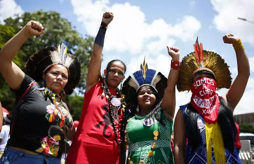 Four women stand together with raised fists during a protest in Brasilia, Brazil, on International Women's Day.