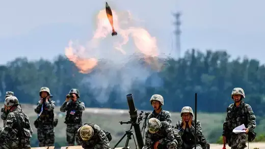 Chinese soldiers fire a weapon.