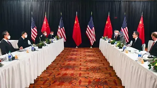 U.S. and Chinese officials sit at tables facing each other. 