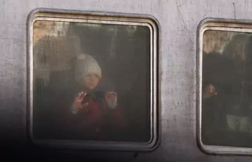 A girl looks out of a train for refugees from north eastern Ukraine fleeing the ongoing Russian invasion, at a train station in Lviv, Ukraine, March 12, 2022