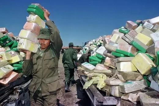 A Mexican soldier carries blocks of cocaine seized in drug raids to an incinerator in Tamaulipas, Mexico. 