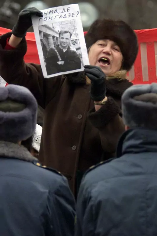 An angry woman shouts and waves a paper with the portrait of opposition journalist Georgi Gongadze, as she takes part in a protest 