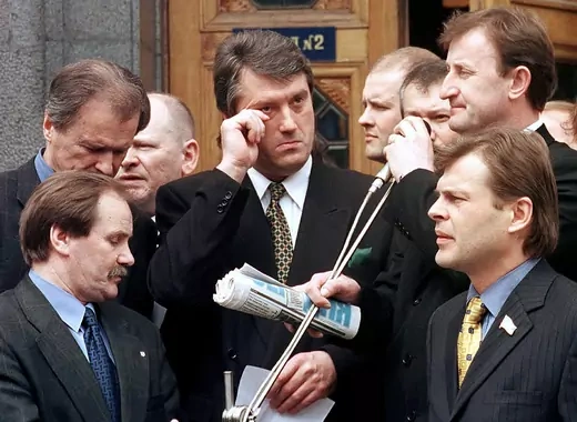 Prime Minister Viktor Yushchenko, surrounded by deputies, wipes away a tear.