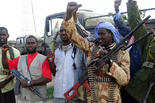 Members of a Somali Islamic Court militia cradle their weapons and raise their fists to celebrate.