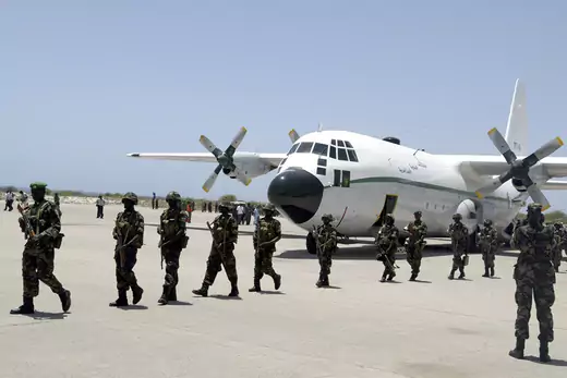 Ugandan soldiers, part of the first African Union peacekeepers, walk of a plane at Mogadishu airport.