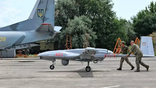 Soldiers push a Bayraktar TB2 drone on a tarmac in southern Ukraine.