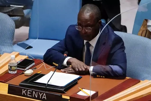 Kenyan Ambassador to the United nations sits in front of his microphone. 