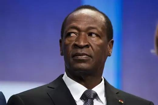 Burkina Faso's former president looks to the side wearing a suit and tie. 