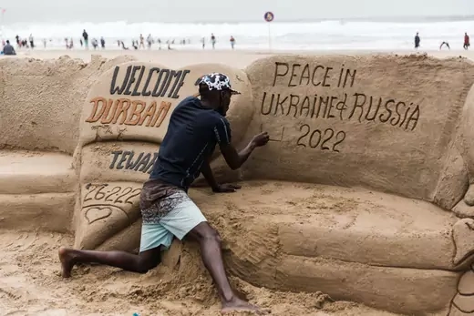 South African sand sculptor Sithembiso Buthelezi gives the final touches showing a message calling for peace between Ukraine and Russia on the North beach in Durban, on February 27, 2022.