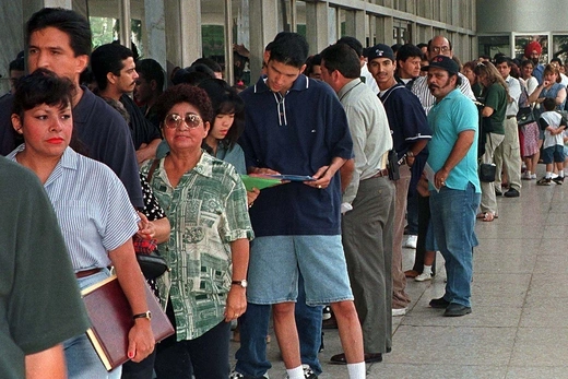 Photo showing a line of immigrants standing outside INS office.