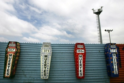 Photo showing an artist’s representation of coffins inscribed with the number of immigrants who died each year while attempting to cross the border between Mexico and the United States.