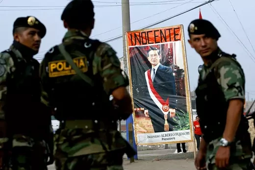 Peruvian police stand next to a poster showing former Peruvian president Alberto Fujimori at the entrance of the Special Police Headquarters in Lima.