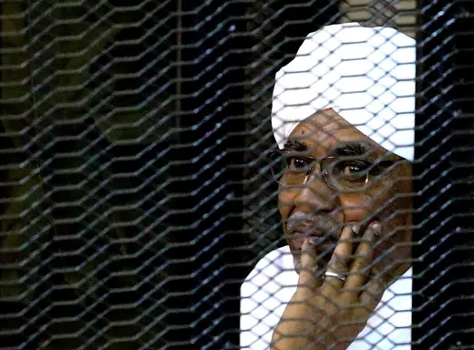 Former Sudanese President Omar al-Bashir sits inside a cage at a Khartoum courthouse.