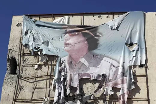 A torn banner showing Muammar Gaddafi is seen on a building in Sirte.