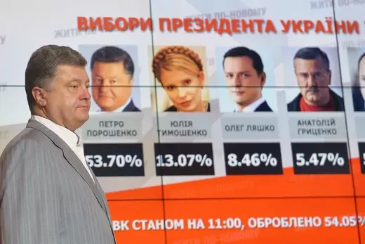 Presidential candidate Petro Poroshenko stands in front of poster displaying other presidential candidate's election results
