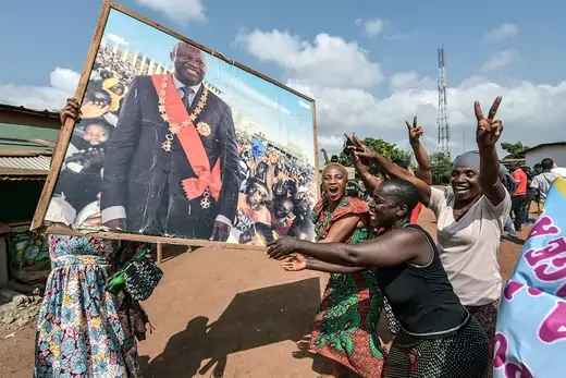 People celebrate with a portrait of former Ivory Coast president Laurent Gbagbo.