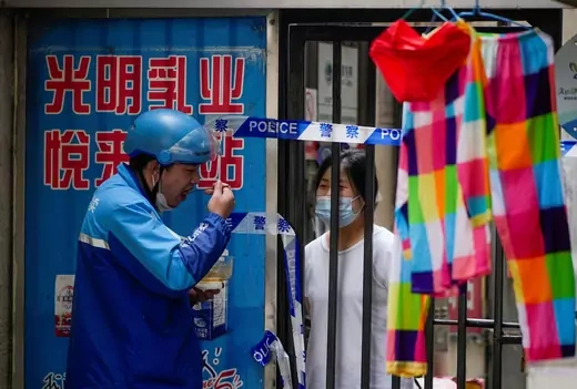 Residents chat through gaps in barriers at a closed residential area during lockdown, amid the coronavirus disease (COVID-19) outbreak, in Shanghai, China, May 27, 2022