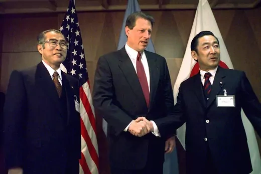 Al Gore shakes hands with Ryutaro Hashimoto as as Japanese Foreign Minister Keizo Obuchi (L) looks on.