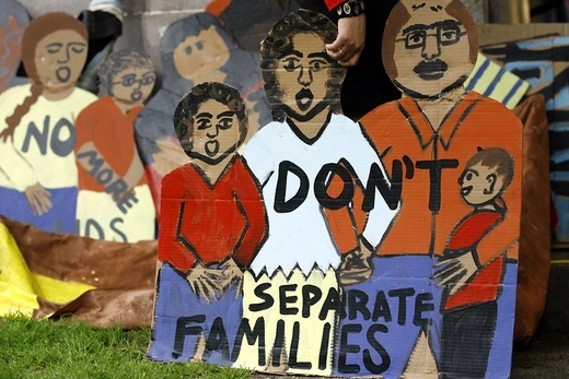 Photo of a banner showing illustrations of an immigrant family and text saying "Don't separate families".