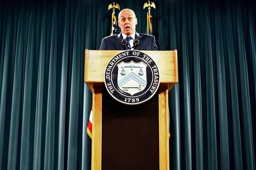Treasury Secretary Henry Paulson seen behind a podium, announces his rescue plan at a September 19 news conference.