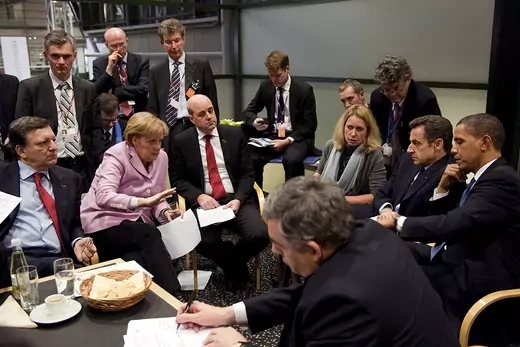 World leaders, including German Chancellor Angela Merkel, French President Nicolas Sarkozy, and U.S. President Barack Obama sit around a table. 