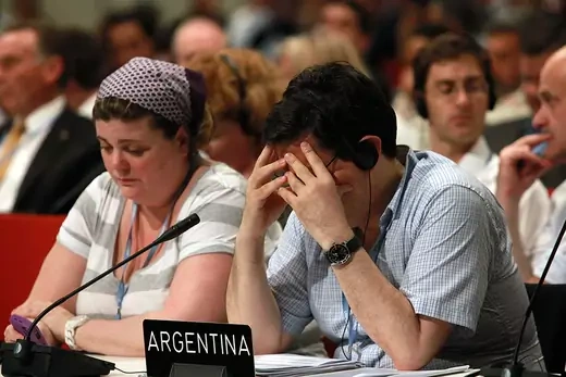 A man from Argentina holds his head in hands during negotiations. 
