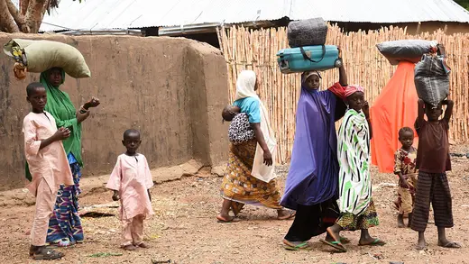 Residents carry their belongings as they leave Kukawa, in northern Nigeria, after their houses were burnt down in an attack by bandits.