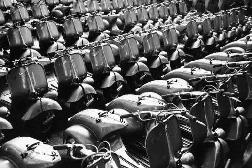 Photo showing rows of Vespa Piaggio motorcycles.