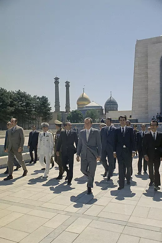 President Nixon surrounded by Iranian and U.S. officials is seen walking in Iran.