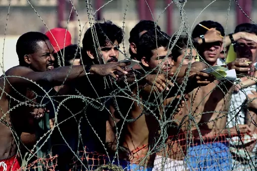 Cuban refugees behind barbed wire at Guantanamo Naval Base.