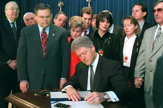 President Clinton signs the Helms-Burton bill.
