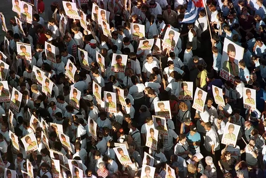 A crowd of protesters carrying poster depicting Elian Gonzales, march in front of the Office of Interests of the United States in Havana