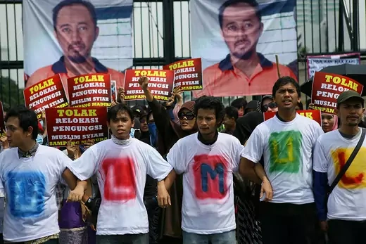 Indonesian Shiites Muslims rally outside the parliament building in Jakarta wearing t-shirts and holding placards.