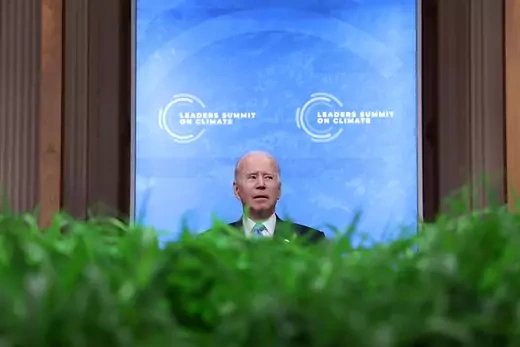 Photo showing President Joe Biden standing behind green plants, addressing world leaders during the virtual climate summit.