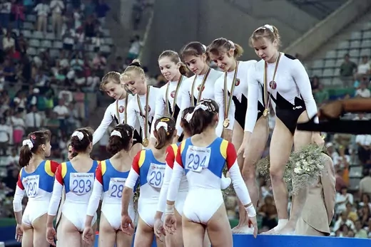 Gymnasts on the Unified Team shake hands with members of the Romanian team.