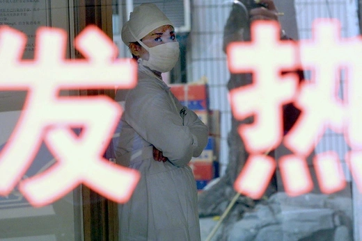 A nurse rests inside a special quarantine ward at a hospital in China’s Guangdong Province in December 2003.